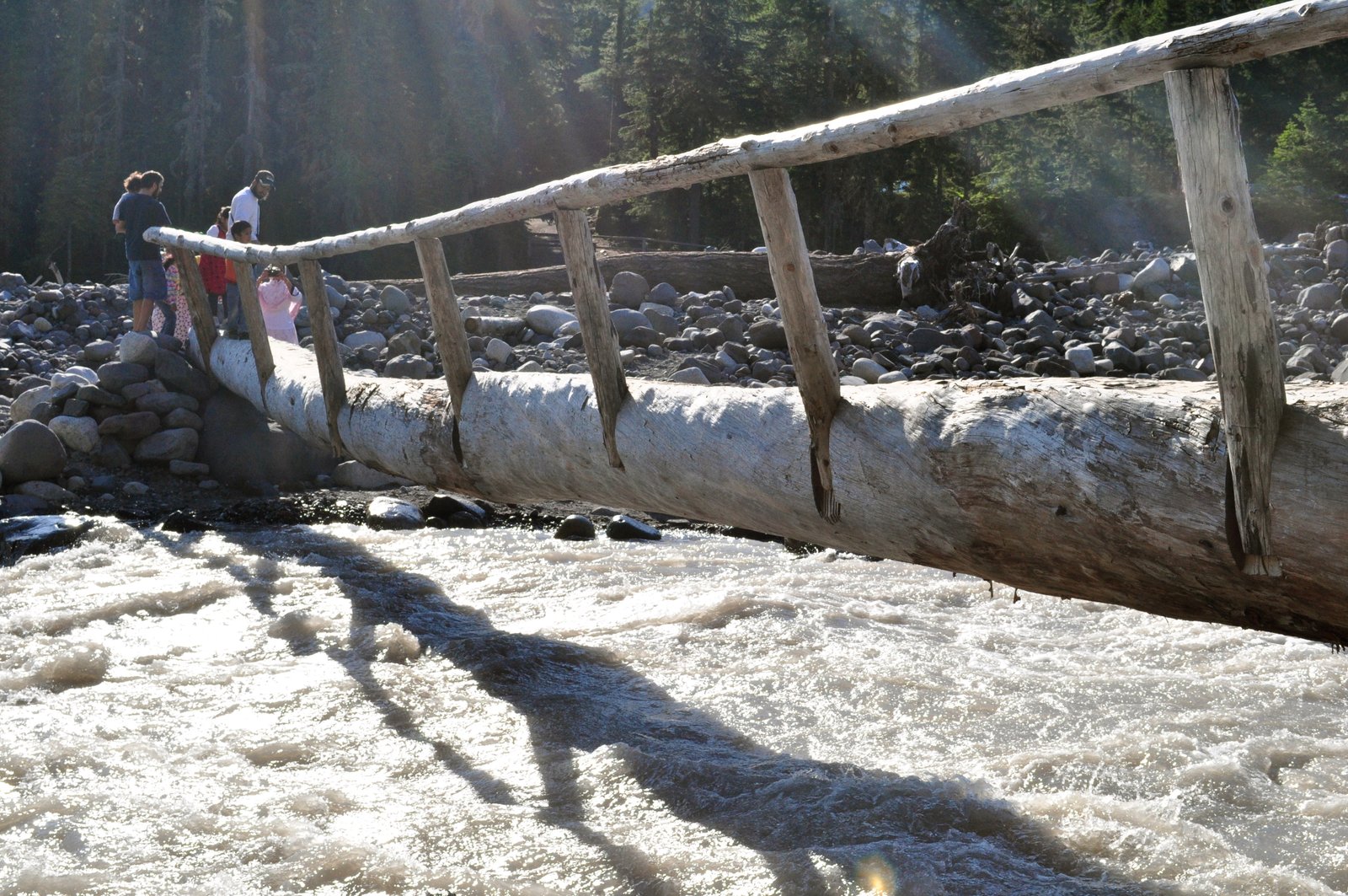 Hiker crossing the Nisqually River near Cougar Rock, Wonderland Trail